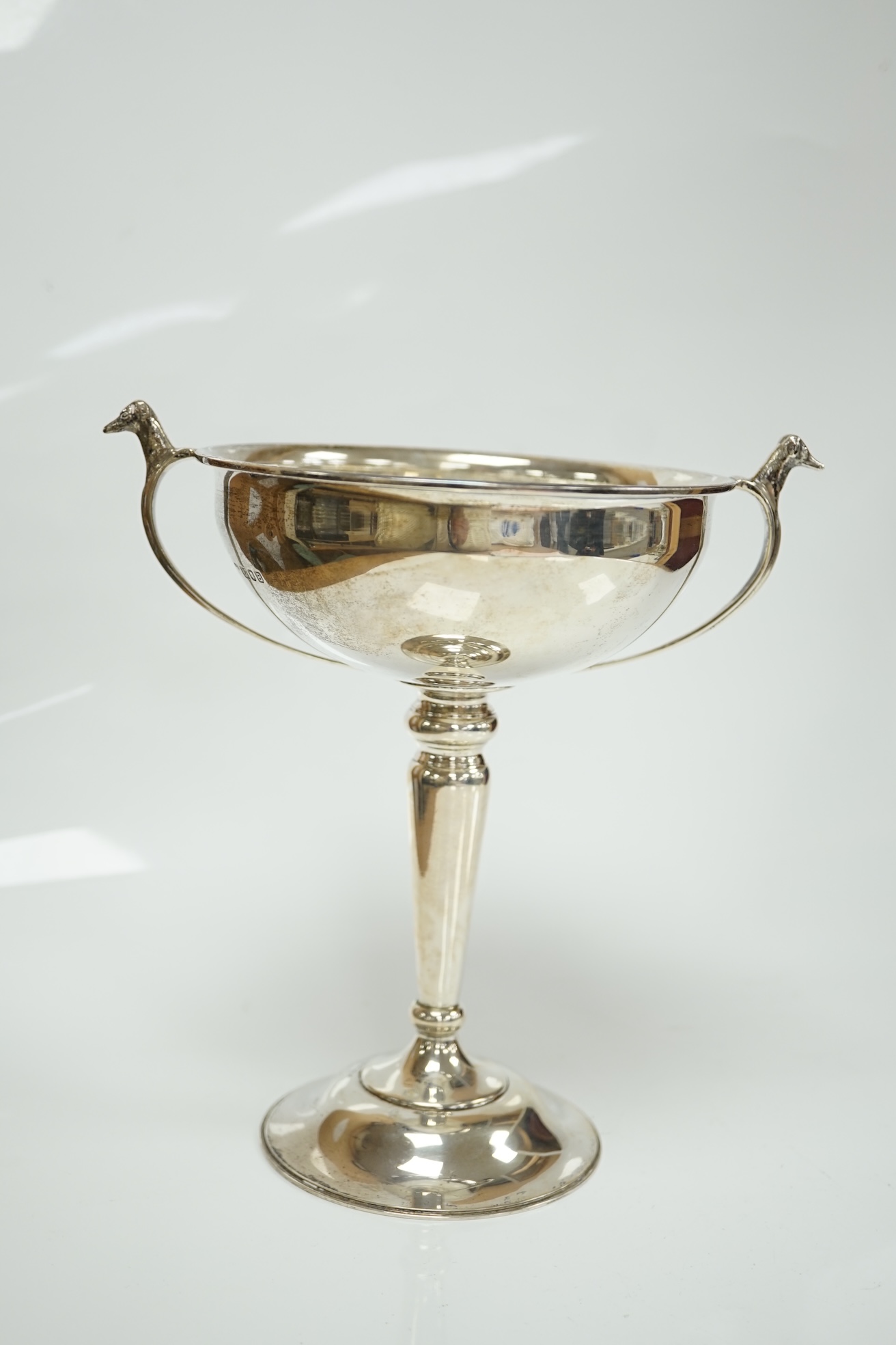 A 1930's silver two handled presentation greyhound trophy cup, with greyhound head handle terminals and engraved inscription, Carrington & Co, London, 1937, 18.7cm, 7.5oz. Condition - poor